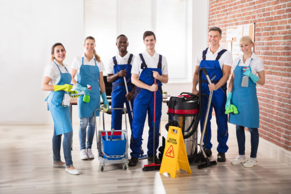 Portrait Of Happy Diverse Janitors In The Office With Cleaning Equipments